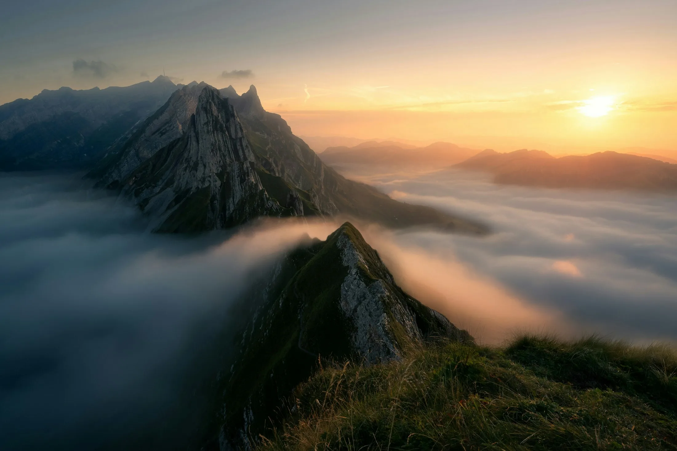 A high alpine ridge rising above cloud at sunrise